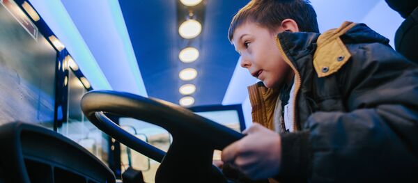 Архивное фото мальчика за рулем учебного симулятора вождения автомобиля - Sputnik Казахстан