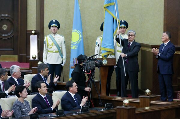 Временный президент Казахстана Касым-Жомарт Токаев держит национальный флаг во время церемонии инаугурации в Астане, Казахстан, 20 марта 2019 года - Sputnik Казахстан