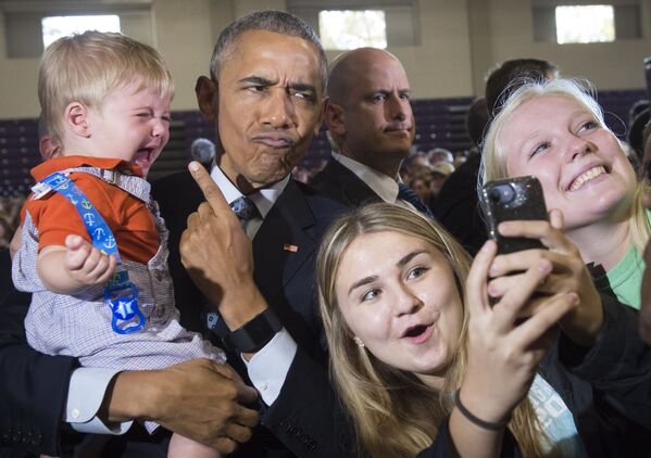 Президент США Барак Обама в окружении сторонников, делающих с ним селфи - Sputnik Қазақстан