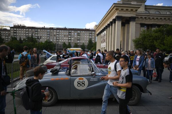 Участники международного ралли на старинных автомобилях Пекин - Париж 2019 на стоянке перед Театром оперы и балета в Новосибирске - Sputnik Казахстан