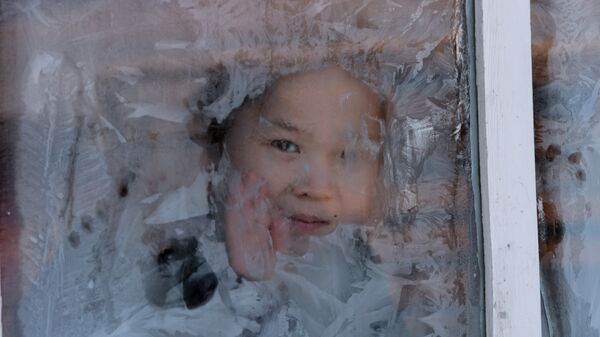 Девочка смотрит в заиндевелое окно, архивное фото - Sputnik Казахстан