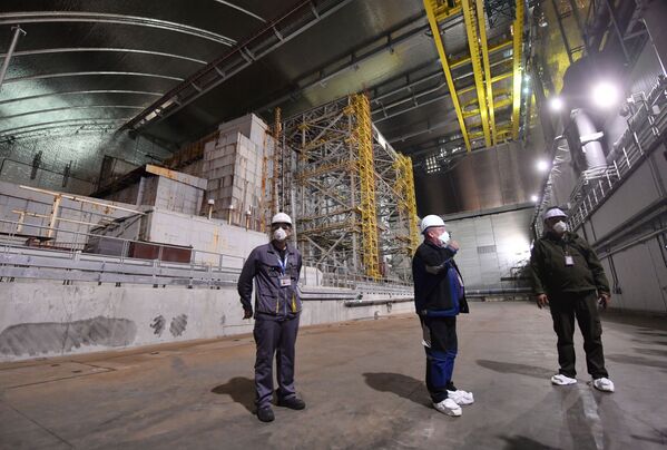 Сотрудники стоят внутри нового металлического саркофага над Чернобыльской АЭС - Sputnik Казахстан