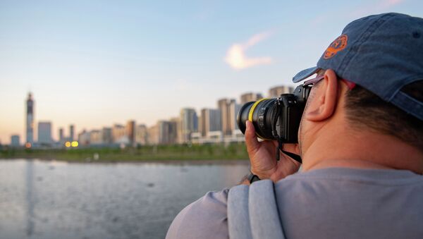 Мужчина с фотоаппаратом на береку реки Ишим - Sputnik Қазақстан