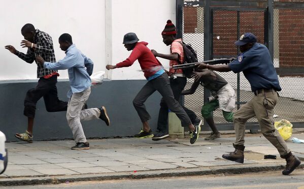 Оңтүстік Африка Республикасының полицейі Преторияда қаласында босқындарға қарсы митингіге шыққандарды қуып барады - Sputnik Қазақстан