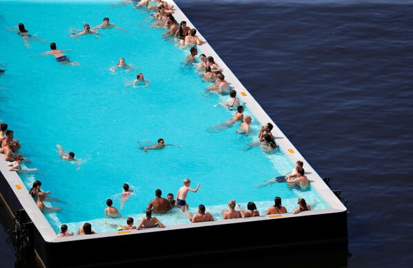 Люди охлаждаются в футуристически спроектированном корабле-бассейне на реке Шпрее в Берлине во время рекордной жары в Германии - Sputnik Казахстан