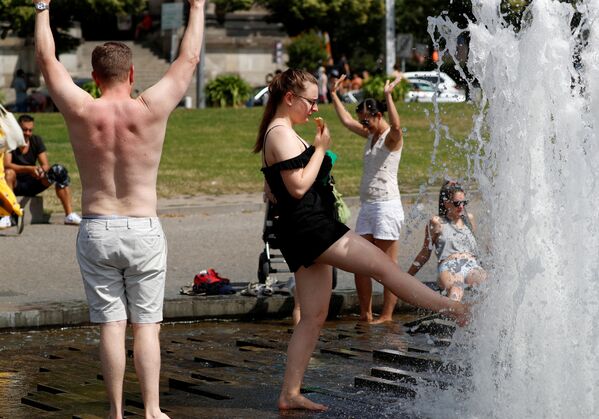 Люди охлаждаются во время жары в фонтане у Берлинского кафедрального собора - Sputnik Казахстан