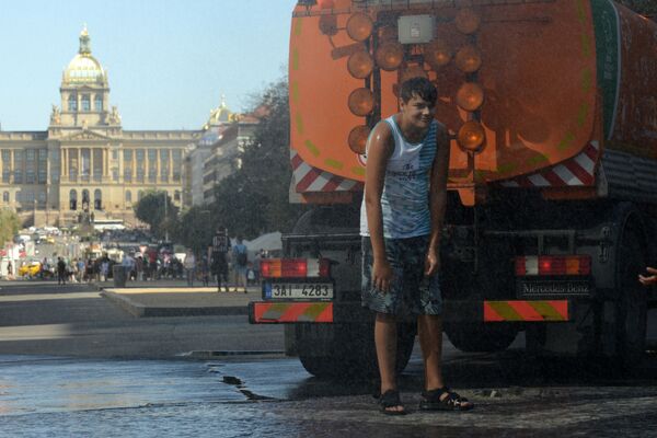 Мальчик остывает под струей воды во время жаркого дня на Вацлавской площади в Праге - Sputnik Казахстан