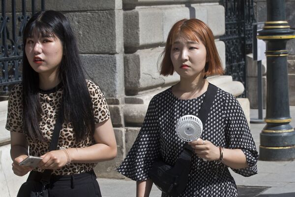 Девушка с портативным вентилятором во время жары в Мадриде, Испания - Sputnik Казахстан