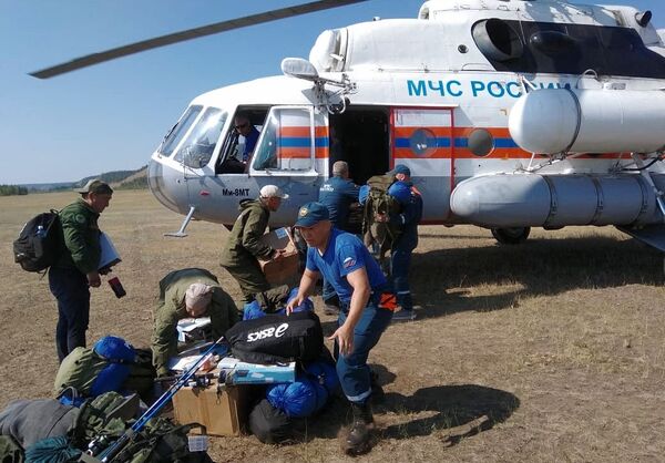 Сотрудники МЧС РФ разгружают специальную технику для тушения лесных пожары в Якутии - Sputnik Казахстан