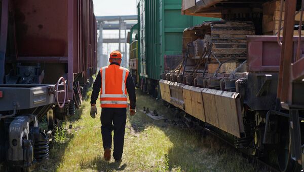 Работник железнодорожных путей, идущий между вагонами, иллюстративное фото - Sputnik Қазақстан