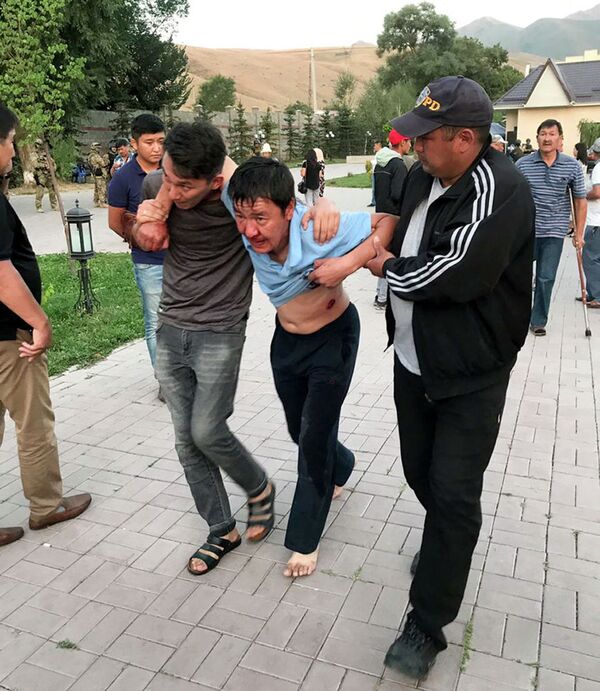 Сторонники бывшего лидера Кыргызстана выводят раненого после захвата резиденции - Sputnik Казахстан