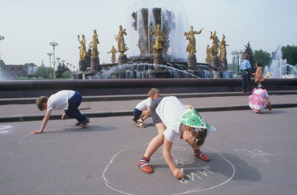 Дети рисуют мелом на асфальте у фонтана Дружба народов в Москве. 1984 - Sputnik Казахстан