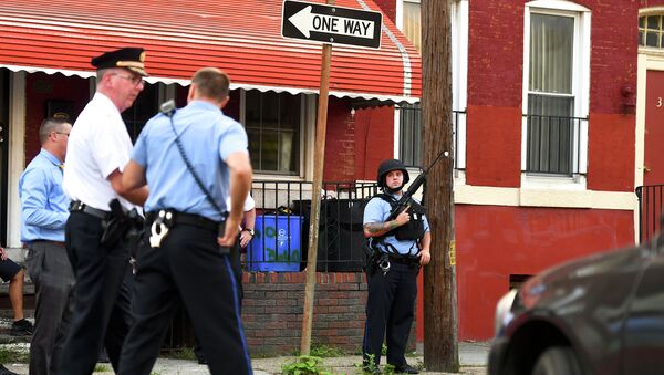  Полицейский с штурмовой винтовкой контролирует деятельность отвечающих на стрельбу 14 августа 2019 в Филадельфии, Пенсильвания - Sputnik Қазақстан