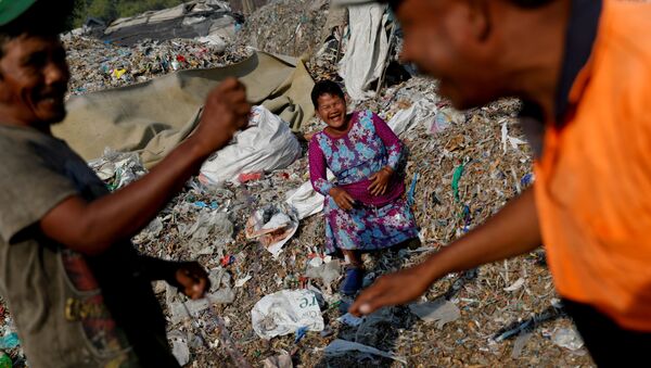 Местные жители рядом с грудами мусора в деревне Багун в Индонезии - Sputnik Казахстан