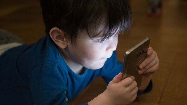 Ребенок играет со смартфоном, иллюстративное фото - Sputnik Казахстан