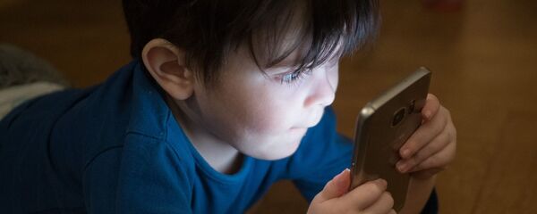 Ребенок играет со смартфоном, иллюстративное фото - Sputnik Казахстан