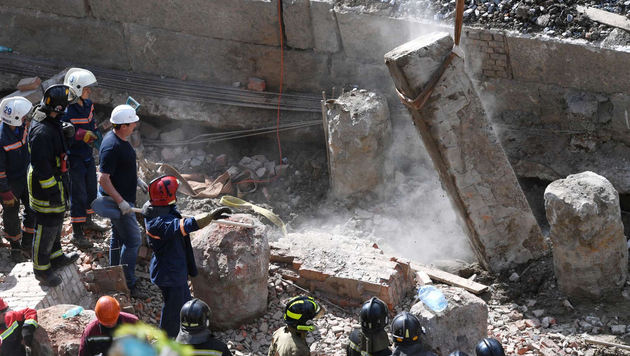 Под завалами остались люди. Спасатели разбирают завалы. Спасатели на обрушении здания.