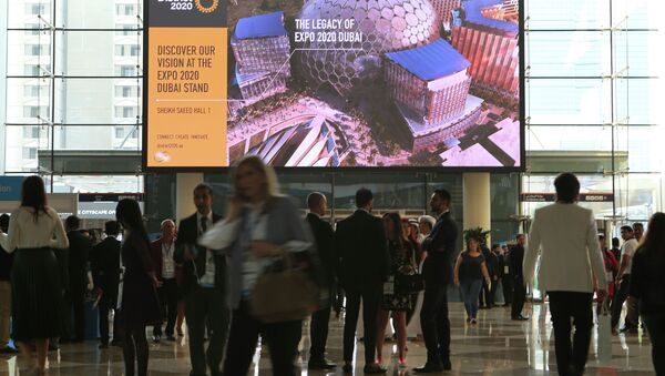 Люди проходят перед рекламным щитом Dubai Expo 2020 - Sputnik Казахстан
