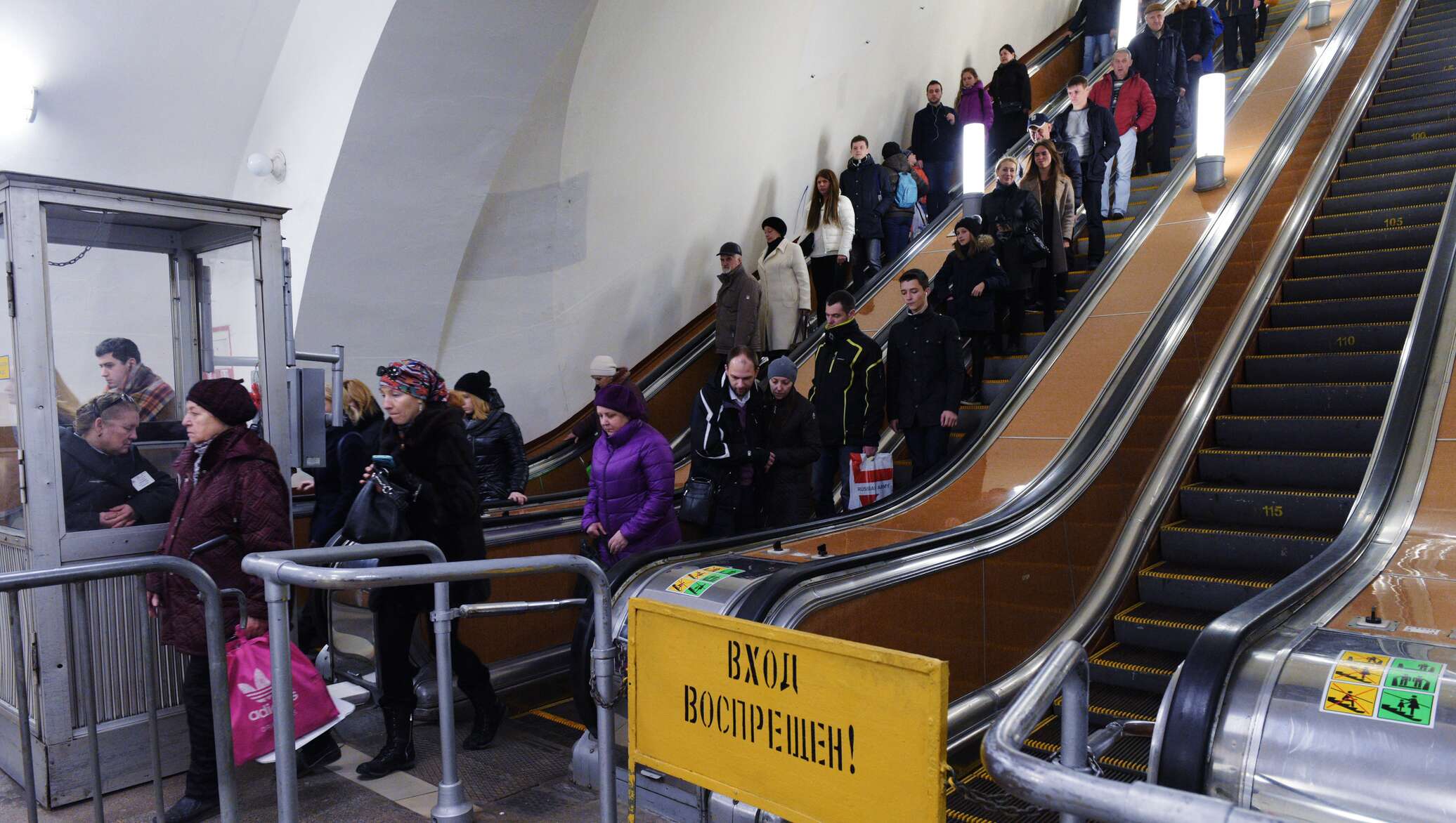 Эскалатор метрополитена поднимает неподвижно. Люди на эскалаторе в метро. Человек спускается в метро. Пассажиры спускаются в метро на эскалаторах. Спуститься в метро на эскалаторе.