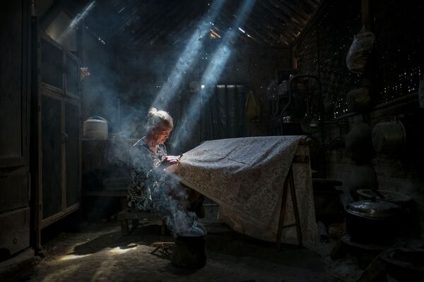 Снимок Under the light making batik crafts индонезийского фотографа Bimo Pradityo, представленный на фотоконкурсе AGORA Awards 2019 - Sputnik Казахстан