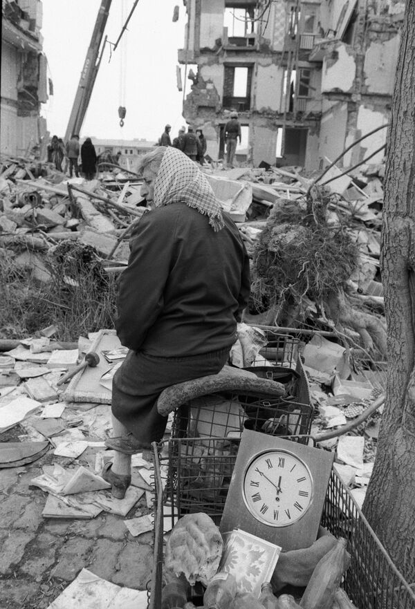 Жительница Спитака на руинах своего дома, разрушенного во время землетрясения. - Sputnik Казахстан