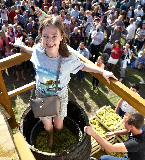 Девушка давит ногами виноград на фестиваля молодого вина «WineFest» в Балаклаве. - Sputnik Казахстан