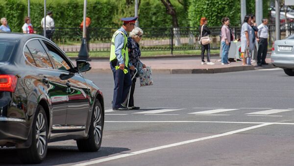 Полицейский помогает перейти дорогу пожилой женщине - Sputnik Казахстан