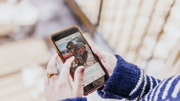 Девушка держит в руках смартфон с открытым приложением Instagram - Sputnik Казахстан