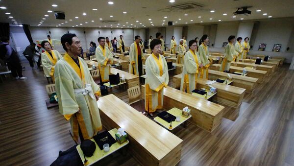 Участники рядом с гроами во время «живых похорон» в Сеуле, Южная Корея - Sputnik Казахстан