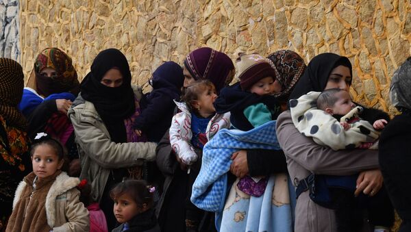Женщины с детьми на руках в окрестностях провинции Идлиб (Сирия), архивное фото - Sputnik Қазақстан