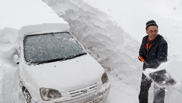 Мужчина откапывает свою машину из снежного сугроба - Sputnik Казахстан