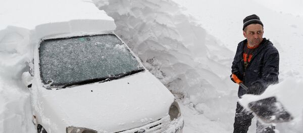 Мужчина откапывает свою машину из снежного сугроба Мужчина откапывает свою машину из снежного сугроба - Sputnik Казахстан