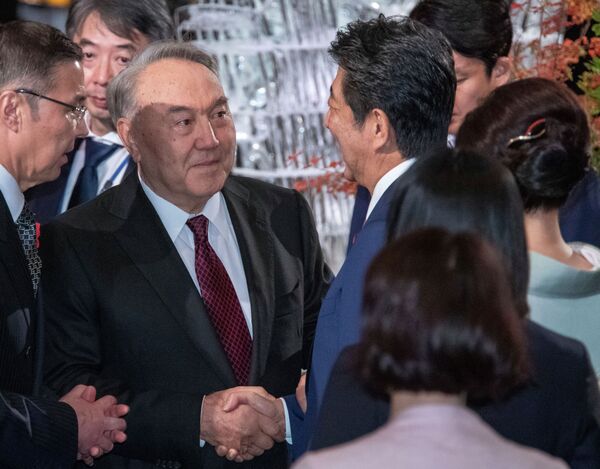 Первый президент Казахстана Нурсултан Назарбаев (второй слева) пожимает руку премьер-министру Японии Синдзо Абэ во время коктейльной вечеринки перед банкетом, устроенным Абэ в Токио в среду, 23 октября 2019 года. (Чжай Цзяньлань / Pool Photo by AP) - Sputnik Казахстан