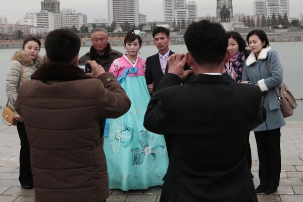 Молодожены во время свадебной фотосессии со своими родственниками в Пхеньяне - Sputnik Казахстан