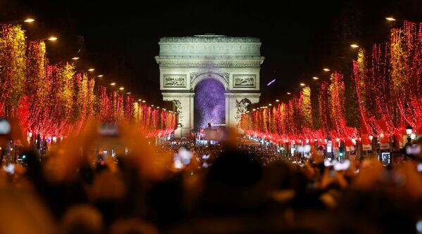 Зрители во время праздничного светового шоу перед Триумфальной аркой в Париже - Sputnik Казахстан