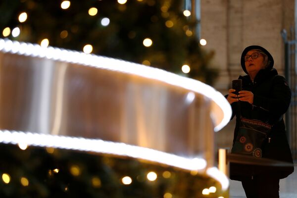 Женщина фотографирует новогоднюю елку в Палаццо Колонна в Риме - Sputnik Казахстан