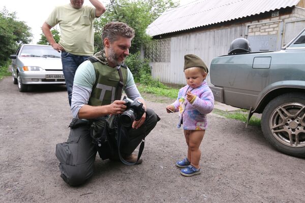 Специальный фотокорреспондент МИА Россия сегодня Андрей Стенин и мальчик Антон Кобченко в селе Семеновка - Sputnik Казахстан