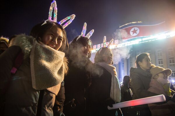 Девушки смотрят запуск салюта во время празднования Нового года в КНДР  - Sputnik Казахстан