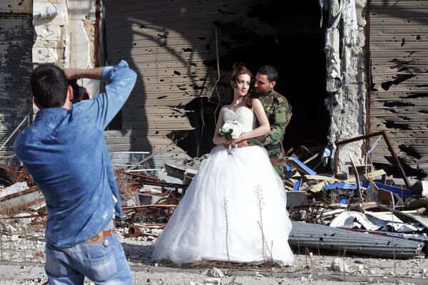 Сирийские молодожены во время фотосессии на фоне разрушенных зданий в Хомсе  - Sputnik Казахстан
