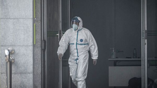 Медицинский работник выходит из больницы в китайском Ухане, где проходят лечение пациенты, инфицированные новым таинственным вирусом - Sputnik Қазақстан