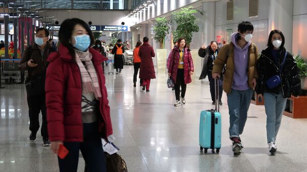 Пассажиры в масках видны в зале терминала международного аэропорта Пекин Столичный в Пекине - Sputnik Казахстан
