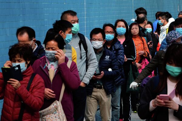 Люди стоят в очереди, чтобы купить маски для лица, чтобы предотвратить вспышку нового коронавируса, в Гонконге, Китай - Sputnik Казахстан