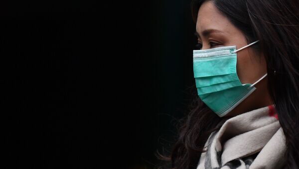 Девушка в медицинской маске в районе Чайна-таун в Лондоне - Sputnik Қазақстан