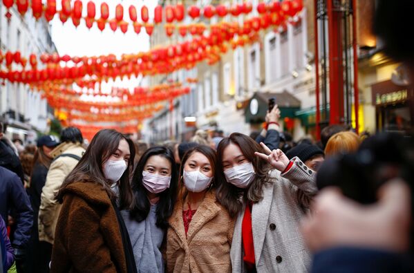 Люди в медицинских масках во время празднования Китайского нового года в районе Чайна-таун в Лондоне - Sputnik Казахстан