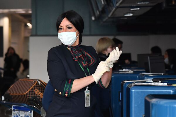 Сотрудница аэропорта в маске и перчатках до проверки пассажиров в Риме  - Sputnik Казахстан