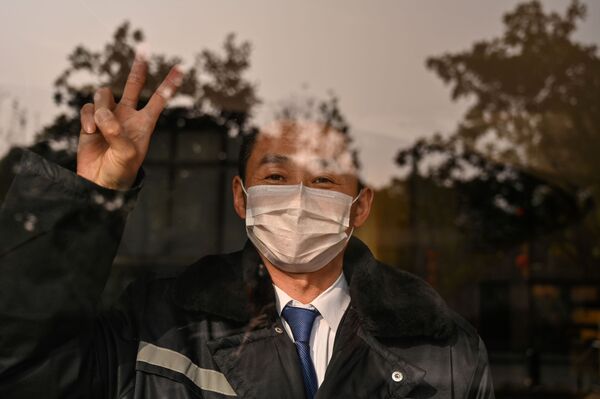 Охранник отеля в маске в китайском городе Ухань  - Sputnik Казахстан