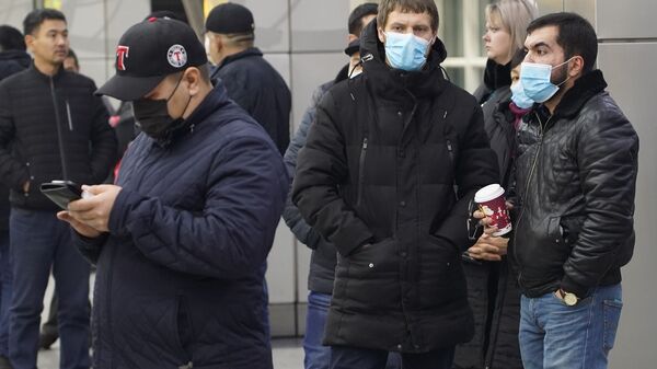 Люди в масках в аэропорту Алматы ожидают прибытия рейса с Хайнаня - Sputnik Казахстан