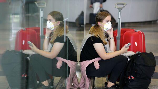 Женщина в защитной маске в аэропорту - Sputnik Казахстан