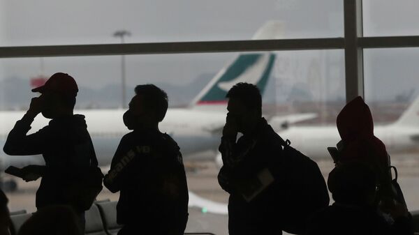 Пассажиры в масках в аэропорту Гонконга - Sputnik Қазақстан