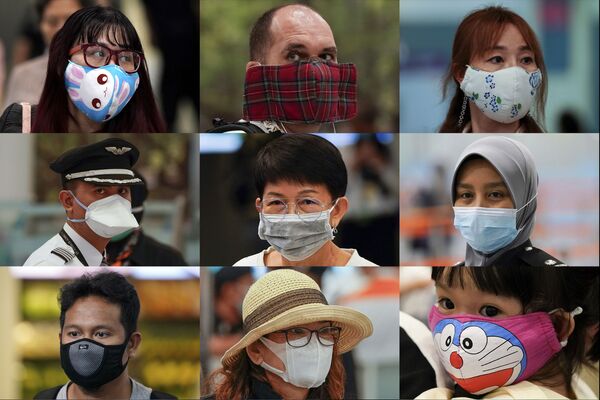 Люди в разных масках у стойки иммиграционной службы в аэропорту города Сепанг, Малайзия - Sputnik Казахстан